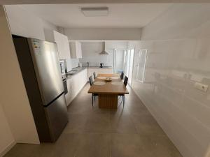 a kitchen with a wooden table and a refrigerator at apartamento san urbano in Almería