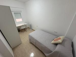 a small bedroom with a bed and a desk at apartamento san urbano in Almería +1 photo