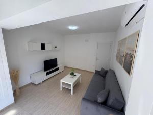 a living room with a couch and a tv at apartamento san urbano in Almería