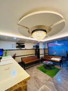 a living room with a couch and a chandelier at L A V Mansion in Bengaluru