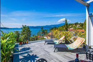 een patio met stoelen en uitzicht op het water bij Stephanina di Lago Loft in Ghiffa