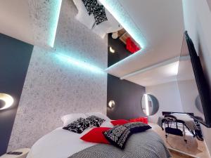 a bedroom with a bed with red and black pillows at Love Room Marseille - Orion in Marseille
