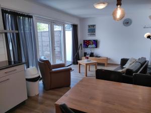 een woonkamer met een bank en een tafel bij Stuivezandeweg 6 in Callantsoog +7 foto's
