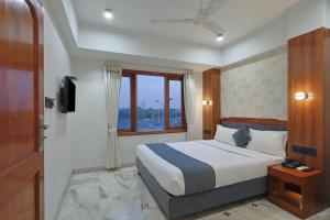 a bedroom with a large bed and a window at Hotel Apex in Surat +51 photos