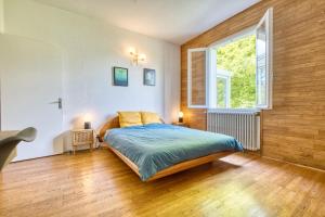 ein Schlafzimmer mit einem Bett und einem großen Fenster in der Unterkunft Appartement La Montagne Sud in Allemans