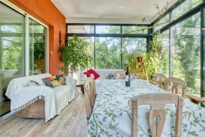 ein Esszimmer mit Tisch und Stühlen und Fenstern in der Unterkunft Appartement La Montagne Sud in Allemans