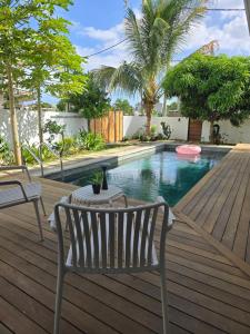 una terrazza in legno con panchina e piscina di Carlos Villa Poolside a Tamarin