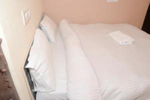 a white bed with white sheets and pillows at SPOT ON Hotel Abhinandan in Meerut +46 photos