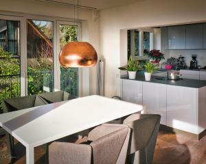 a kitchen and dining room with a white table and chairs at Panoramahaus Pool in Weil am Rhein +19 photos
