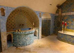 ein Badezimmer mit einer Badewanne und einem Waschbecken mit roten Kerzen in der Unterkunft Riad Cherifa in Chefchaouen