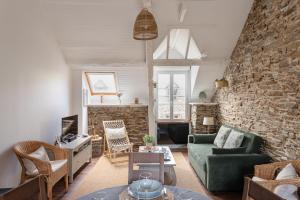 カンカルにあるRêve Emeraude - 100m de la Plageの石壁のリビングルーム(緑のソファ付)