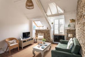 カンカルにあるRêve Emeraude - 100m de la Plageの緑のソファとテレビのあるリビングルーム