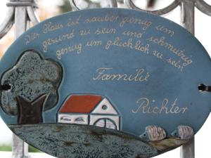 a metal sign with a picture of a house at Ferienwohnung Möhneblick in Möhnesee +27 photos