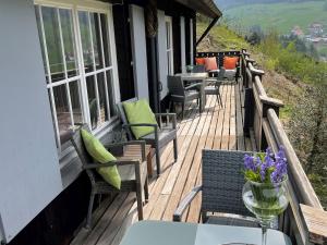 a wooden deck with chairs and tables on a house at Ferienhaus Lena in Seebach