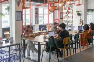 un grupo de personas sentadas en mesas con ordenadores portátiles en YellowSquare Milan, en Milán