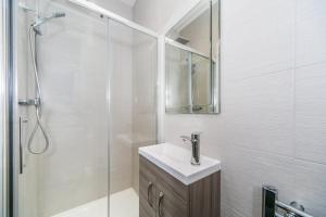 a white bathroom with a sink and a shower at Flat 14 Helena House 1-Bed Sleeps 3 Parking in Reading +4 photos