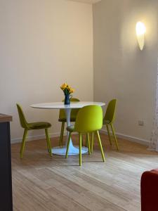 ein Esszimmer mit einem Tisch und grünen Stühlen in der Unterkunft La Movida in Lecco