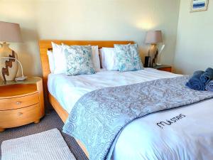 Un dormitorio con una cama grande con almohadas azules y blancas. en Bluebird Empire Penthouse, en Muizenberg