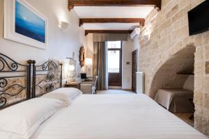 sypialnia z dużym łóżkiem i kamienną ścianą w obiekcie Santo Stefano Home & Breakfast w mieście Polignano a Mare