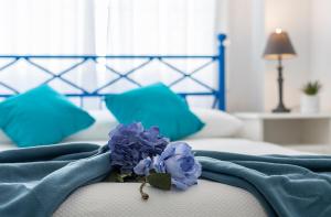 a blue blanket with a blue flower on a bed at Apartamentos Collado Playa Valdelagrana in El Puerto de Santa María