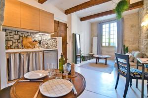 a kitchen with a table and a dining room at La suite du Duché in Uzès