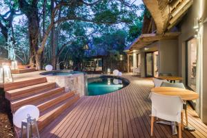フッドスプルイトにあるAM Lodge - Hoedspruitのデッキ(プール、テーブル、椅子付)