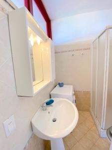 a bathroom with a white sink and a toilet at Bilocale Climatizzato Mare Blu in Marina di Bibbona +5 photos