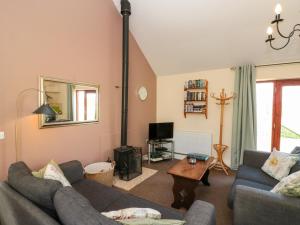 a living room with two couches and a tv at Partridge Cottage in Filey