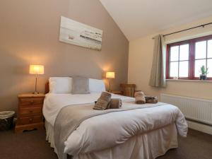 a bedroom with a large bed and a window at Partridge Cottage in Filey