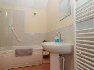 a bathroom with a sink and a toilet and a tub at Partridge Cottage in Filey +22 photos