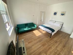 a bedroom with a bed and a couch at The Essex Atelier Studio Flat 2 in Chelmsford +1 photo
