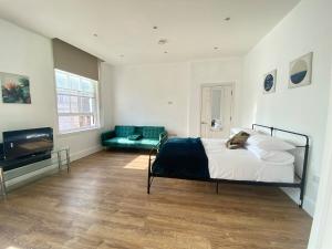 a bedroom with a bed and a flat screen tv at The Essex Atelier Studio Flat 2 in Chelmsford
