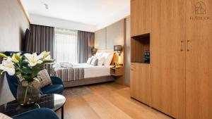 a hotel room with a bed and a vase of flowers at Flatbook - City Center SPA Apartments Deo Plaza Studio in Gdańsk +21 photos