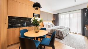 a hotel room with a bed and a table and chairs at Flatbook - City Center SPA Apartments Deo Plaza Studio in Gdańsk