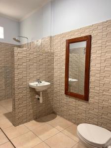 a bathroom with a sink and a toilet and a mirror at Holiday Guest House in Amed