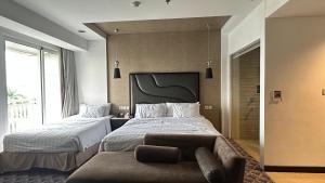 a bedroom with two beds and a couch at Bellevue Radio Dalam in Mantaak