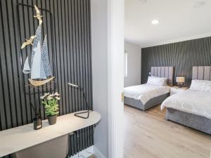 a bedroom with two beds and a desk in a room at Number 6 Villa - The View in Doirí Beaga