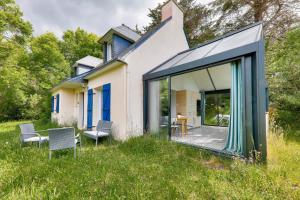 a house with sliding glass doors and a patio at 800 m plage - Belle maison 4 adultes - 2 enfants in Saint-Gildas-de-Rhuys