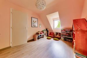 an attic room with a large door and a window at 800 m plage - Belle maison 4 adultes - 2 enfants in Saint-Gildas-de-Rhuys