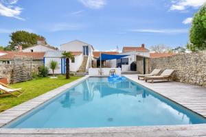 a swimming pool in the backyard of a house at Piscine chauffée, jardin, magnifique villa pour 10 in La Guérinière