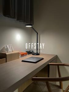 a laptop sitting on a desk with a lamp on it at OFF STAY, hotel in Seoul - 10m from Airport, 8m to Subway in Seoul