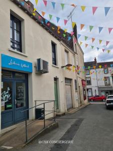 Una calle con banderas colgando sobre un edificio en Le Repère Charmant Appartement Familial au Cœur des Herbiers à 12 min du Puy duFou, en Les Herbiers