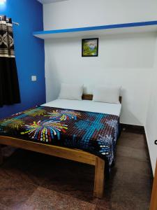 a bedroom with a bed in a blue room at Valley View by Green Trails in Chikmagalūr