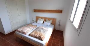 a small bedroom with a bed with white sheets and pillows at Casa El Garrobo in El Garrobo