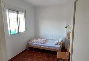 a small bedroom with a bed and a window at Casa El Garrobo in El Garrobo