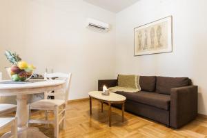 a living room with a couch and a table at Restored Historic APT in Plaka,Under the Acropolis in Athens +9 photos