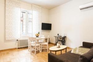 a living room with a couch and a table at Restored Historic APT in Plaka,Under the Acropolis in Athens