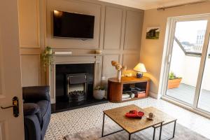 a living room with a fireplace and a tv at Sarahs Home Away from Home Luxury Apartment in Ennis