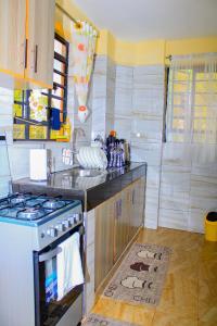 a kitchen with a stove and a counter top at Gardenview Homes -2 Bedroom Apartment along Nyeri-Nanyuki Road -Kingongo in Nyeri +2 photos