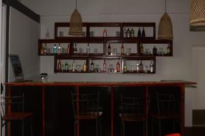 a bar with two chairs and bottles on shelves at Blackstone Sands Resort Bilene in Vila Praia Do Bilene